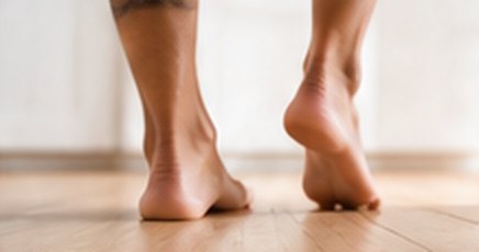 Bare feet walking on a wooden floor