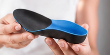 Hand holding a custom orthotic insole